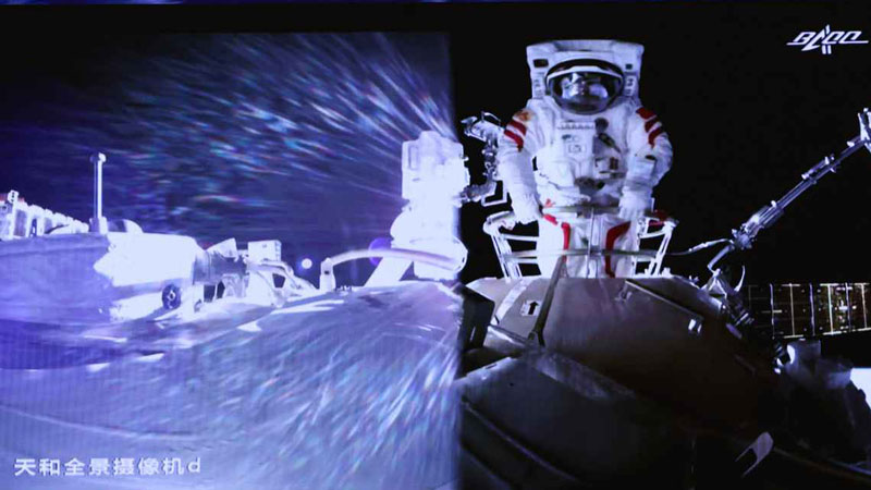 Chinese astronauts step out of spacecraft on robotic arm