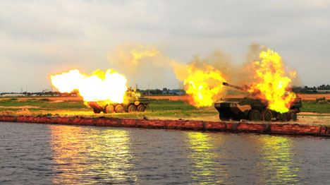 Self-propelled howitzers fire high explosive shells