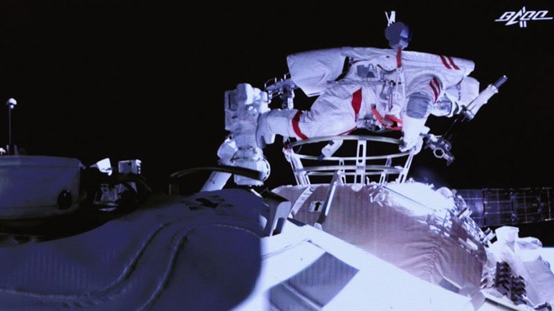 Chinese astronauts step out of spacecraft on robotic arm