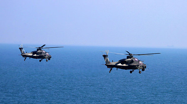 Attack helicopters hover above sea