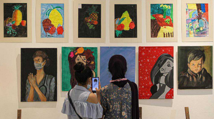 Visitors view artworks made by Palestinian children during exhibition in Gaza City