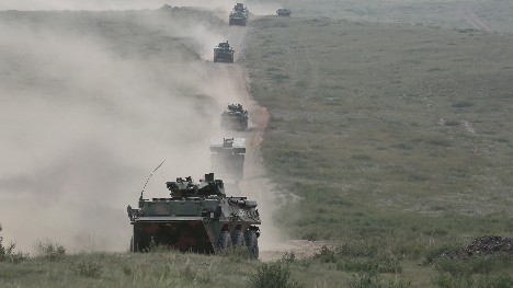Armored vehicles maneuver to training base