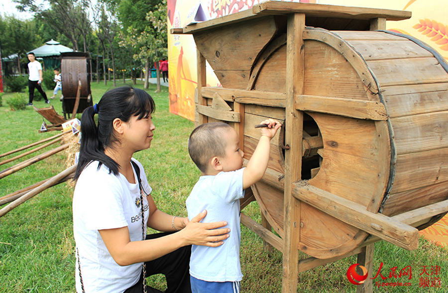 Children get hands-on experience using traditional farm tools in Tianjin, N China
