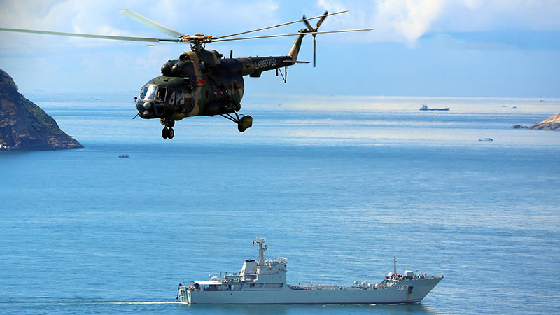 Army helicopters coordinate with naval landing ships in joint training