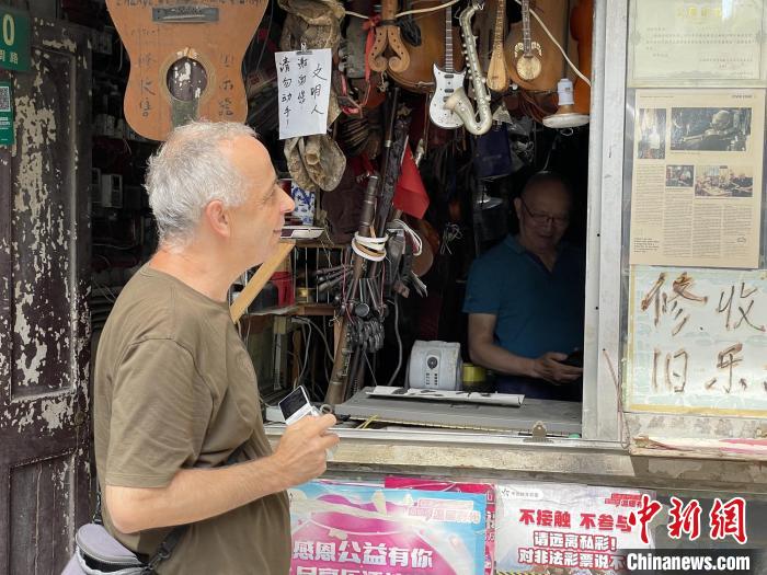 Corner street musical instrument repair shop becomes a popular site for visitors in Shanghai