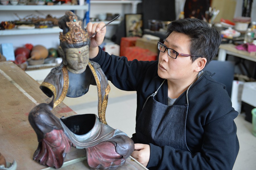Photo shows Zhu Bing, an inheritor of Fuzhou’s bodiless lacquerware painting techniques, working on a Buddha statue. (Photo courtesy of Zhu Bing)