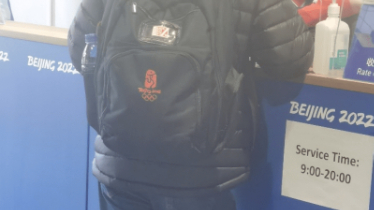 Photographer wears Beijing 2008 Olympic backpack at Beijing 2022 media center