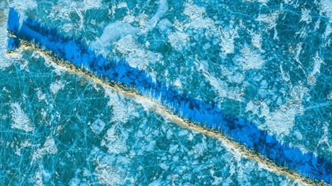 Bountiful green grass awaits sheep herds on frozen Puma Yumco Lake in SW China's Tibet