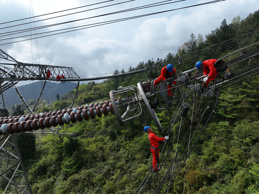 Maintenance workers check, repair power transmission line in SW China’s Chongqing