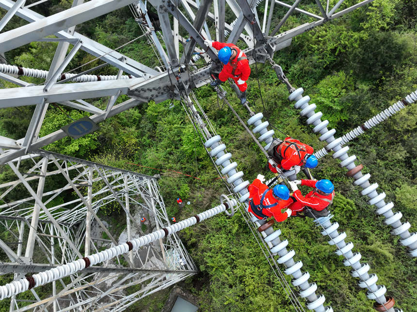 Maintenance workers check, repair power transmission line in SW China’s Chongqing