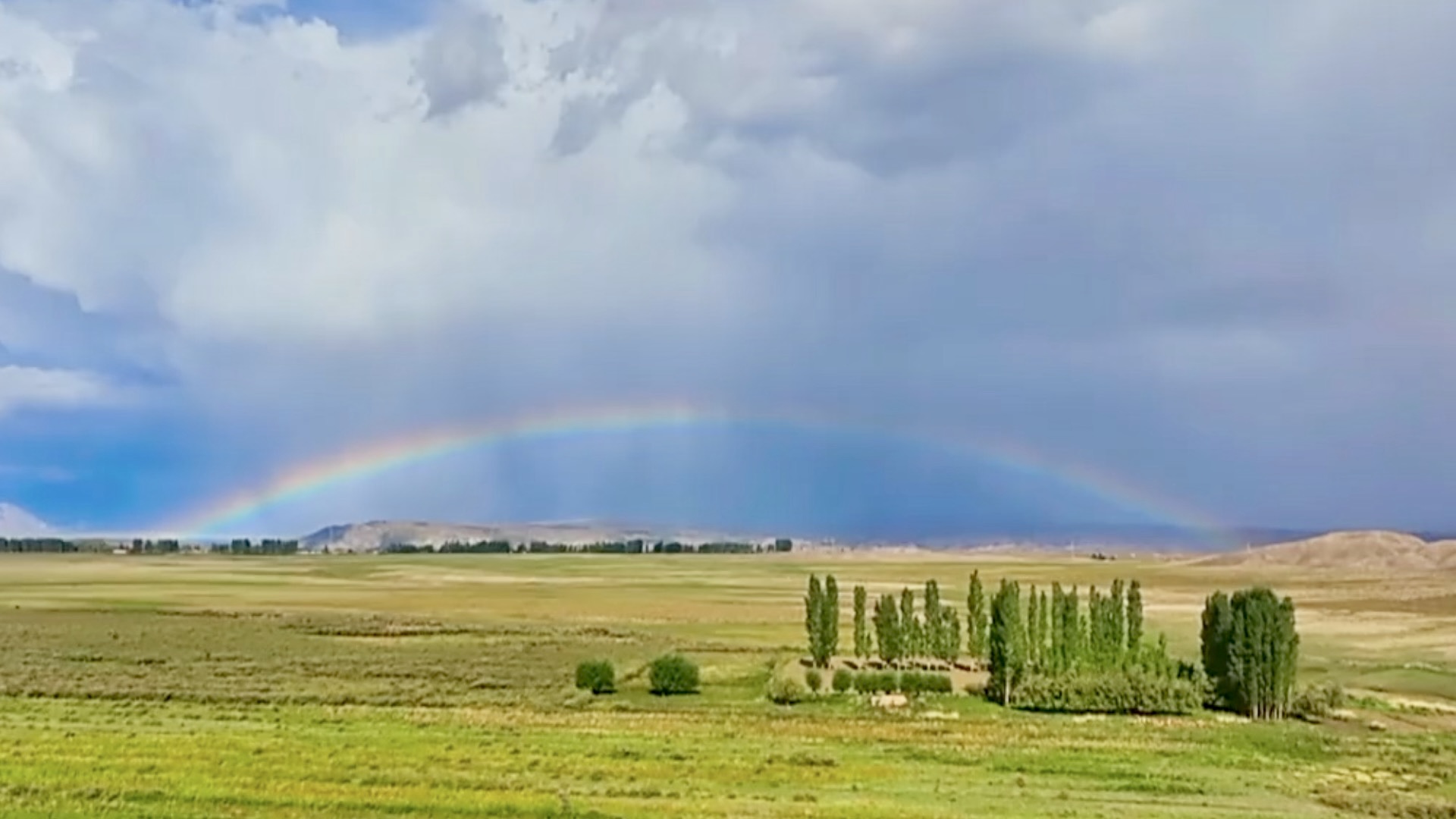 Stunning rainbow reigns over mountains and fields in China's Xinjiang