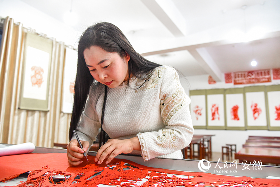 Craftswoman from E China's Anhui carries forward paper cutting culture with passion, devotion