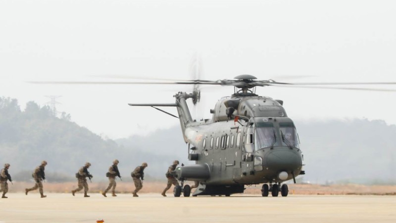 Soldiers rush to board helicopter during air-ground exercise