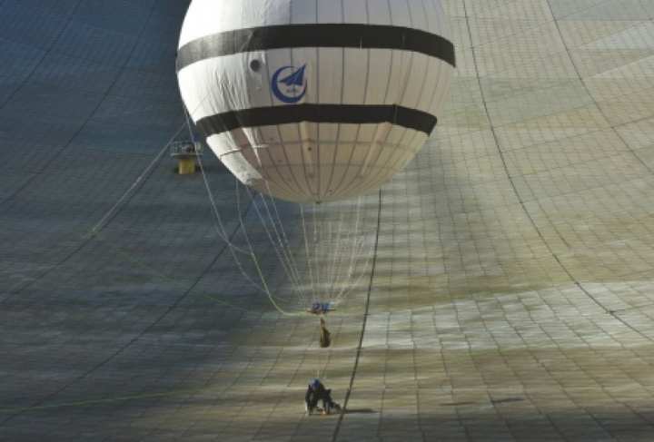 Cleaner tied to a helium balloon to maintain radio telescope
