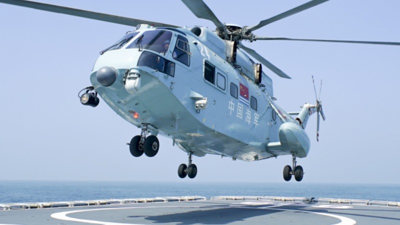 Helicopter coordinates with warship in rescue exercise
