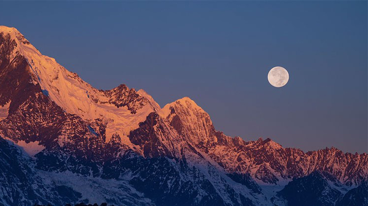 Stunning views of Meili Snow Mountains bathed in light of full moon