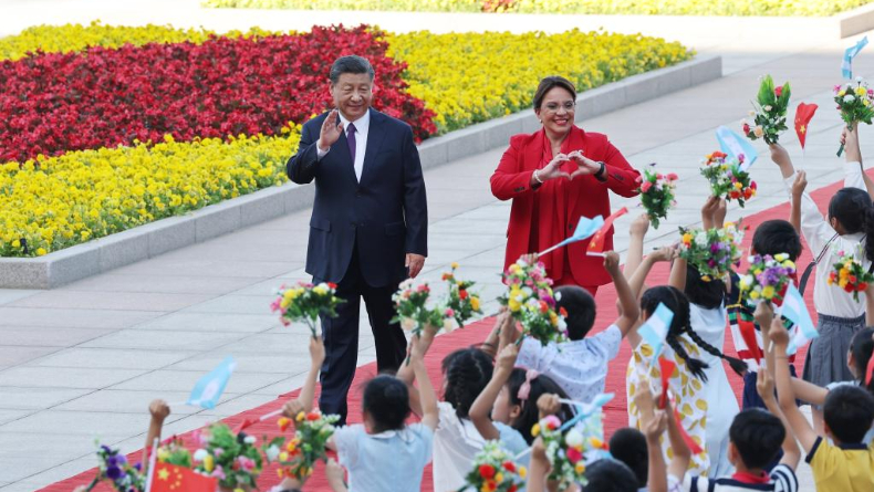 Honduras President Xiomara Castro makes a heart gesture to greet welcoming children