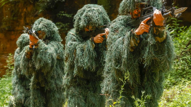 Snipers wearing ghillie suits engage mock targets
