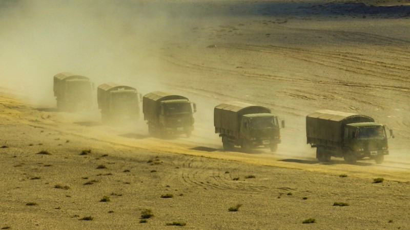 Military vehicles maneuver in desert