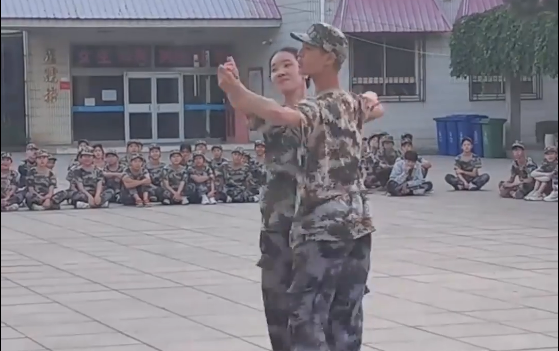Senior schoolmates perform ballroom dancing for freshmen during military training break