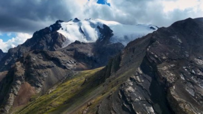 Snowy peaks of Tianshan Mountains in clouds