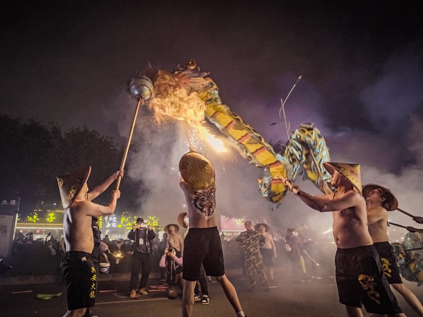 People perform firecracker dragon dance in S China's Guangxi