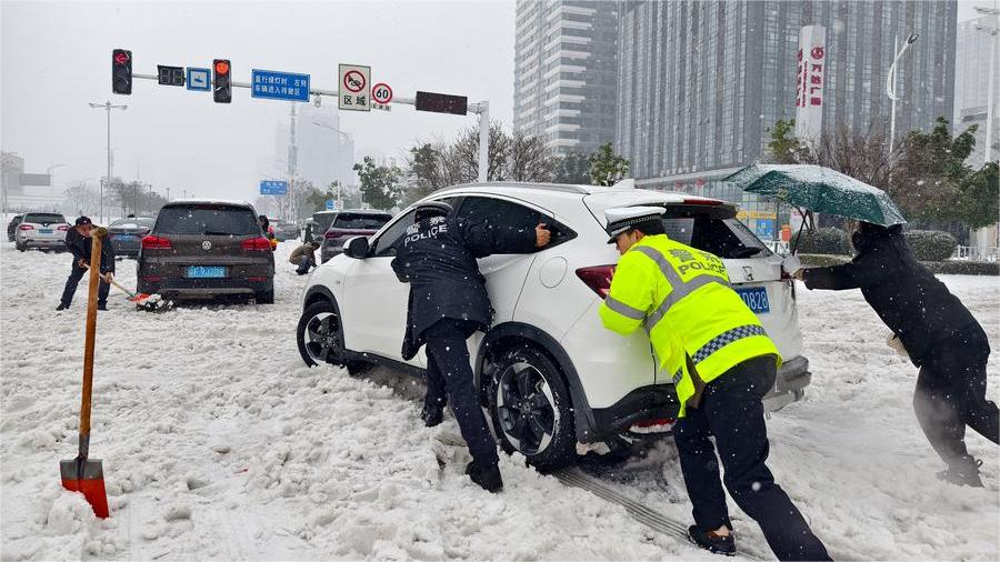 Xinjiang traffic police officer braves blizzard to guide cars