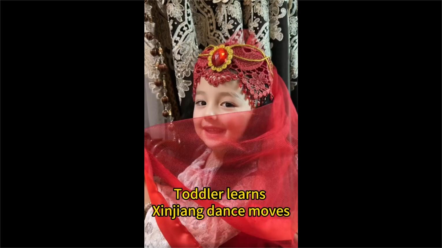 Toddler learns Xinjiang dance moves