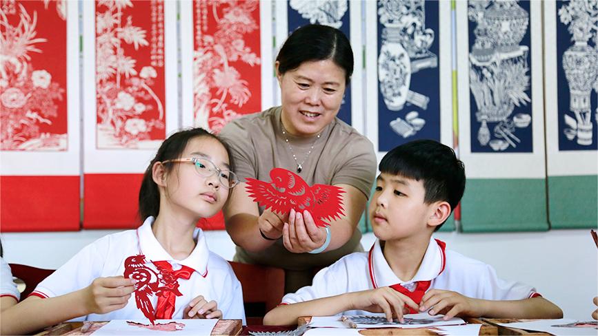 Inheritor passes on traditional paper cutting in N China's Tianjin