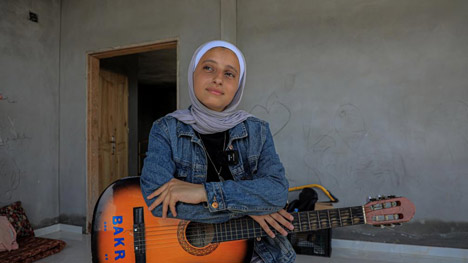 Volunteers strum songs of hope to soothe broken people in Gaza
