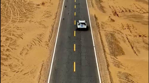 绿树成荫的公路横穿中国最大的沙漠