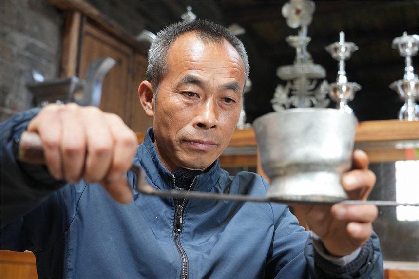 Inheritor passes on tin carving techniques in China's Jiangxi