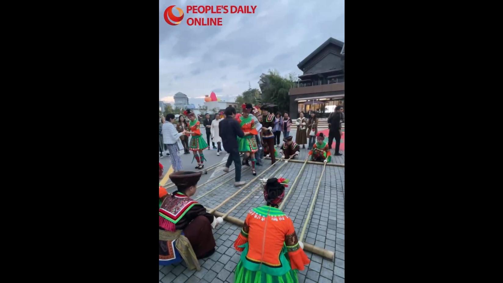 Journalists from Asia-Pacific countries perform a bamboo dance in SW China's Guizhou