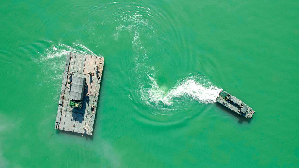 Pontoon troops ferry military vehicles across river