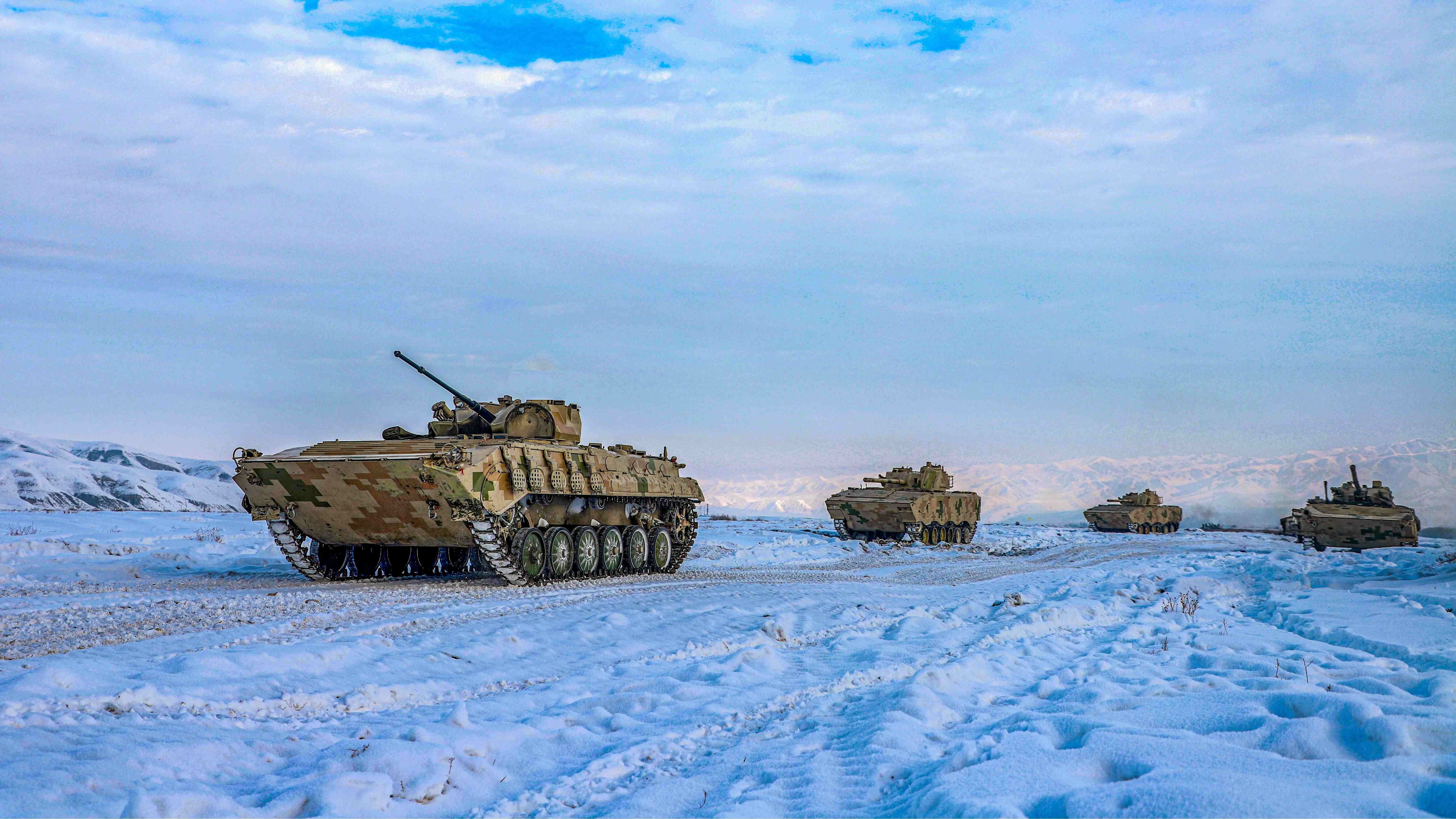 Armored vehicles march on snow field