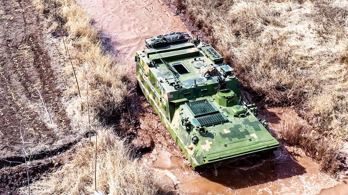 Armored vehicles rumble through muddy puddles
