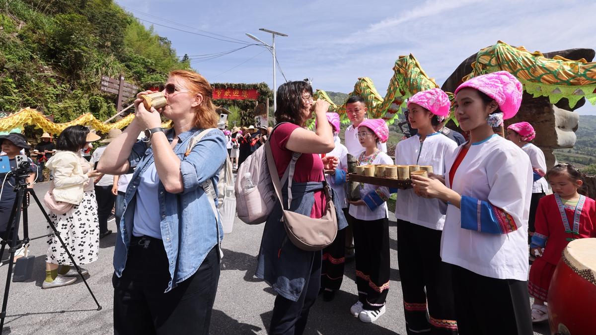 Foreign visitors embrace Chinese farming culture in Guangxi terraced fields under 'China Travel' boom