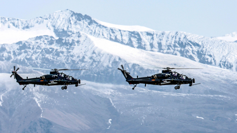 Helicopters fly in mountainous plateau area