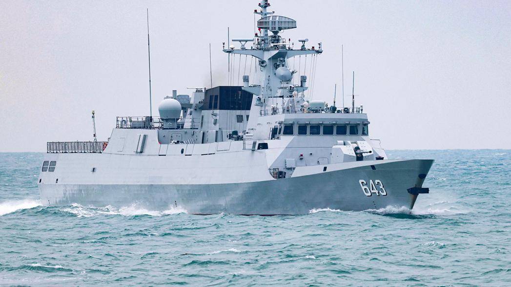 Naval frigate bathes in sunset glow