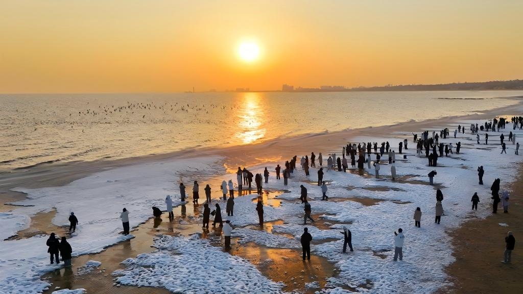Tourists visit beach covered with sea ice in N China's Hebei