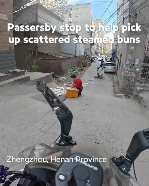 Passersby stop to help pick up scattered steamed buns