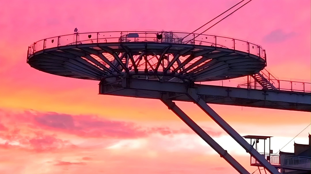 Orange-red sunset illuminates glass viewing platform in Huangshi