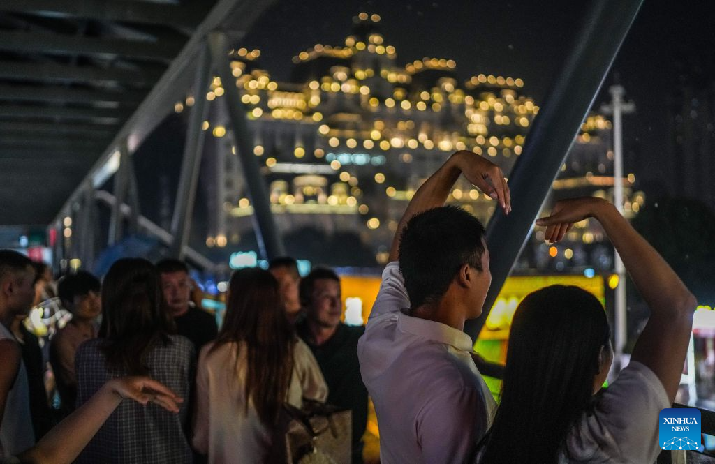Visitors pose for photos at Huaguoyuan in Nanming District of Guiyang, southwest China's Guizhou Province, Aug. 14, 2026. The cool climate and rich tourism resources in Guizhou have attracted lots of visitors seeking a summer retreat. (Xinhua/Tao Liang)