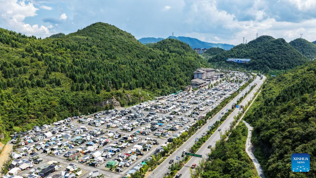 An aerial drone photo shows RVs from across the country parking at an RV camping base in Bijie, southwest China's Guizhou Province, Aug. 11, 2026. The cool climate and rich tourism resources in Guizhou have attracted lots of visitors seeking a summer retreat. (Xinhua/Tao Liang)