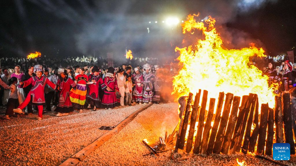 Visitors and local people enjoy themselves around a bonfire in Yi-Hui-Miao Autonomous County of Weining, Bijie, southwest China's Guizhou Province, Aug. 6, 2026. The cool climate and rich tourism resources in Guizhou have attracted lots of visitors seeking a summer retreat. (Xinhua/Tao Liang)