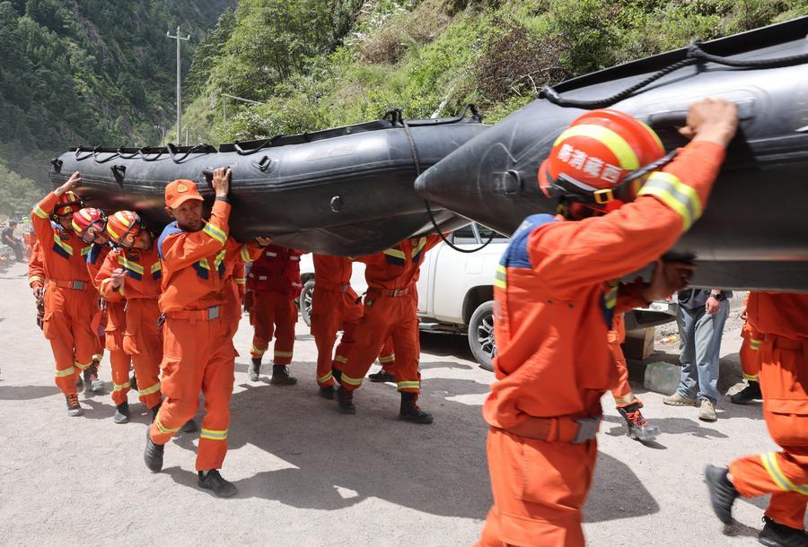 Rescuers carry inflatable rescue boats to the mudslide-hit area on Aug. 28, 2026. (Xinhua/Jiang Fan)