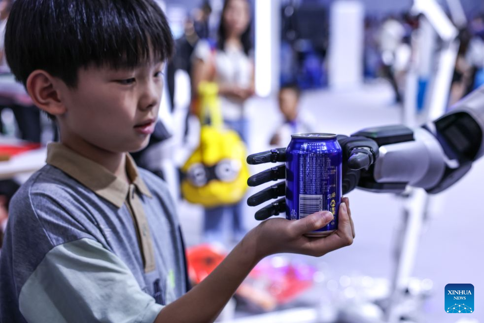 A child interacts with a robot during the professional exhibition of the 2026 China International Big Data Industry Expo in Guiyang, southwest China's Guizhou Province, Aug. 28, 2026. Themed "Token: A New Path to Value of Data Elements," the expo spotlights cutting-edge innovations integrating data with artificial intelligence. (Xinhua/Yang Wenbin)