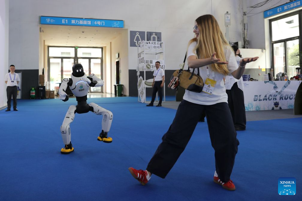 A journalist interacts with a robot during the professional exhibition of the 2026 China International Big Data Industry Expo in Guiyang, southwest China's Guizhou Province, Aug. 28, 2026. Themed "Token: A New Path to Value of Data Elements," the expo spotlights cutting-edge innovations integrating data with artificial intelligence. (Xinhua/Li Xulun)