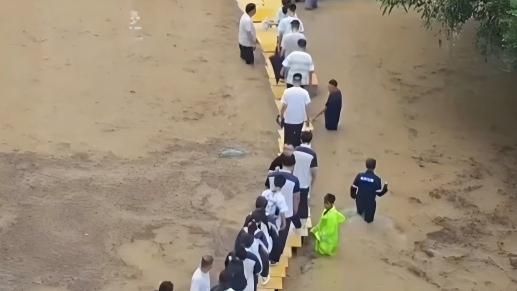 Staff improvise 'desk bridge' to evacuate flooded school