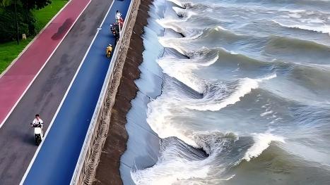 Qiantang River waves form graceful curves along the embankment